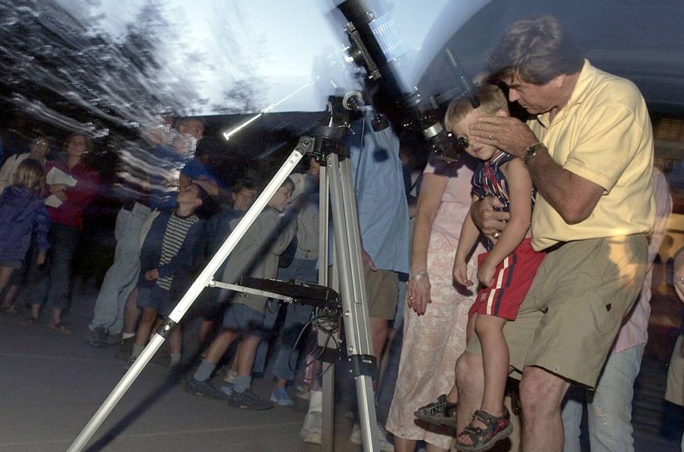 Don Mayer, of San Antonio, Texas, holds his grandson Haydon Mayer, 4, to help him look at the p ...