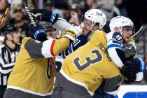 Golden Knights right wing Mark Stone, left, fights with Jets left wing Kyle Connor, second from ...