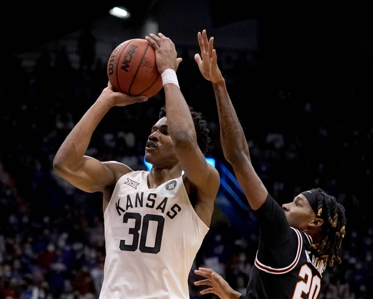 Kansas guard Ochai Agbaji (30) shoots under pressure from Oklahoma State guard Keylan Boone (20 ...