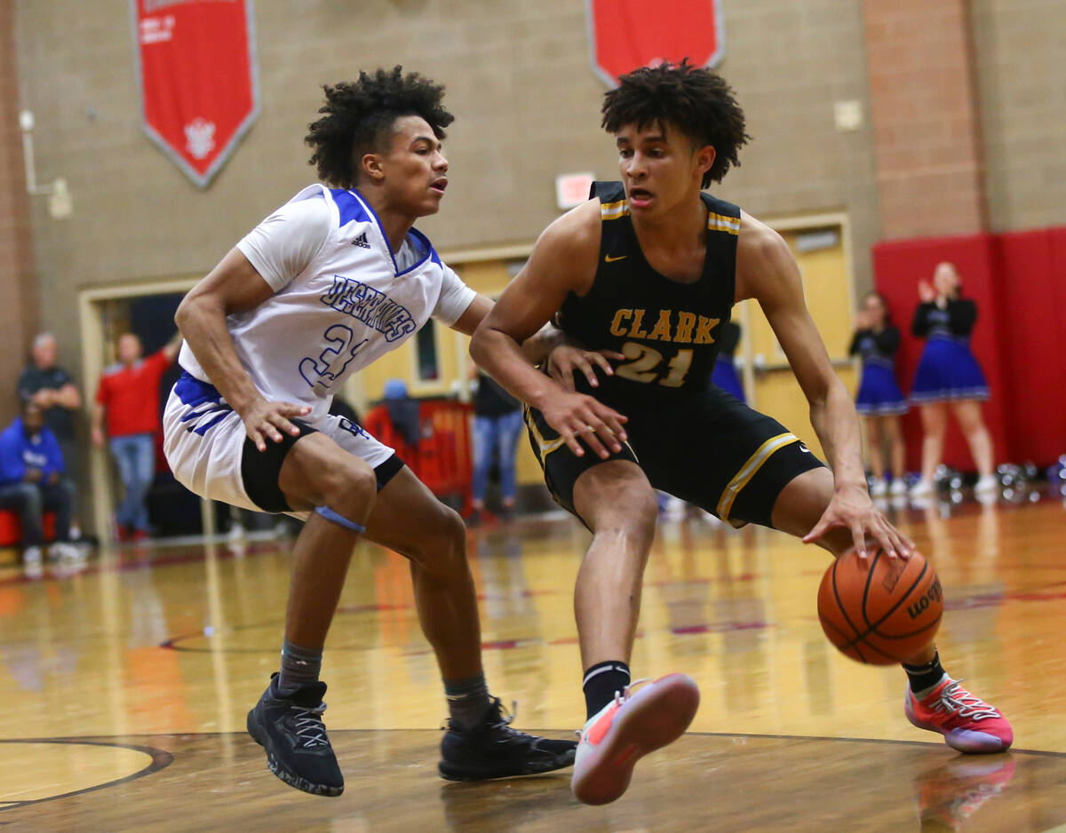 Clark's Jalen Hill (21) moves the ball around Desert Pines' Jamir Stephens (33) during the seco ...