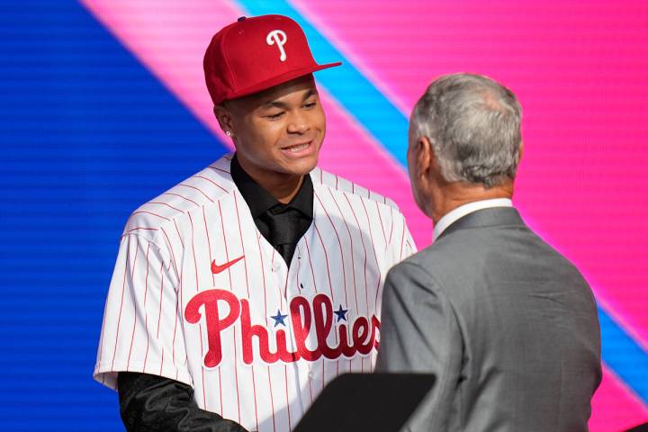 Justin Crawford, left, shakes hands with MLB Commissioner Rob Manfred after being selected by t ...