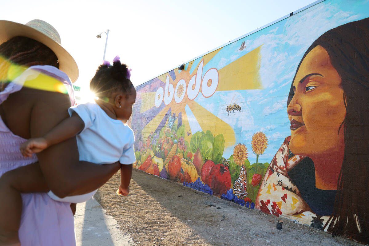 The setting sun peaks through Jillian White, left, while she holds her granddaughter Luna Helen ...