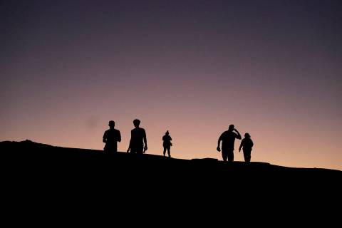 People visit Zabriskie Point as the sun sets, Thursday, Sept. 1, 2022, in Death Valley National ...
