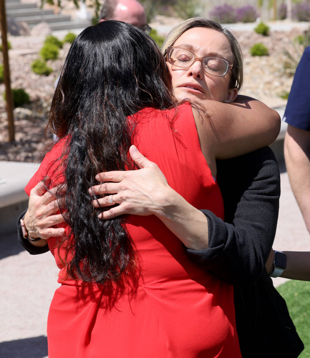 Dr. Tammera Flores, right, a colleague of slain Dr. Gwen Amsrala, gets a hug from Internal Medi ...