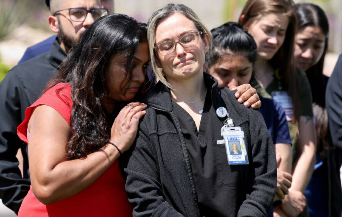 Dr. Tammera Flores, right, a colleague of slain Dr. Gwen Amsrala, gets a hug from Internal Medi ...