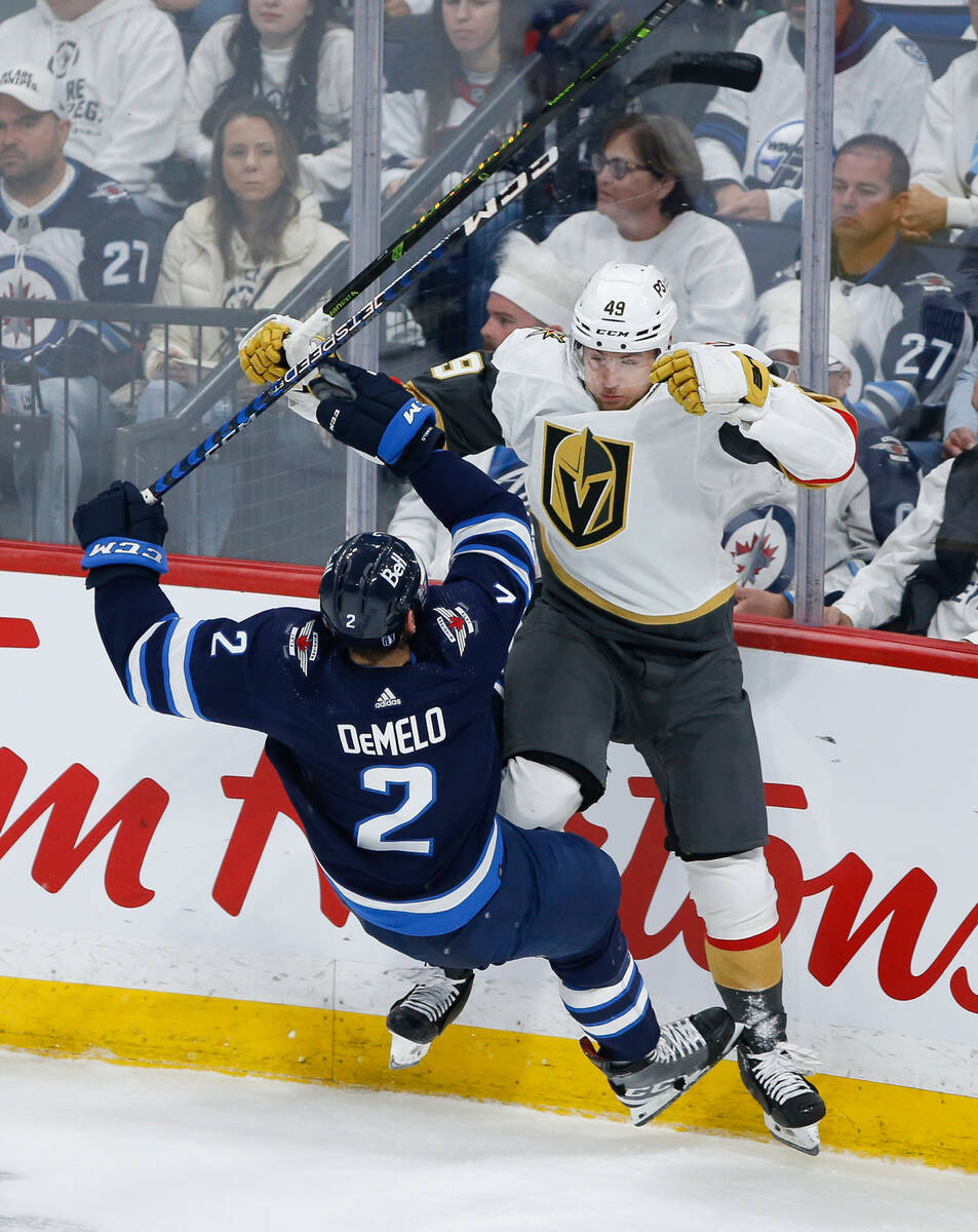 Winnipeg Jets' Dylan DeMelo (2) and Vegas Golden Knights' Ivan Barbashev (49) collide during th ...