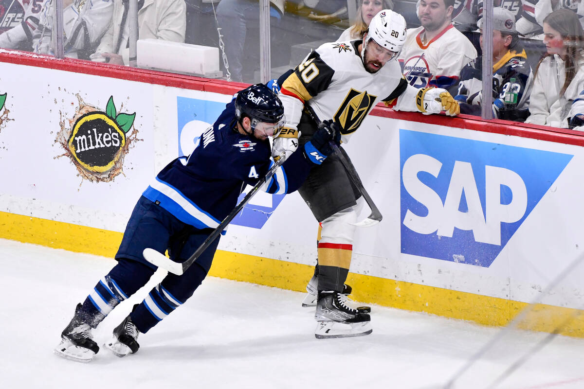 Winnipeg Jets' Neal Poink (4) checks Vegas Golden Knights' Chandler Stephenson (20) during the ...