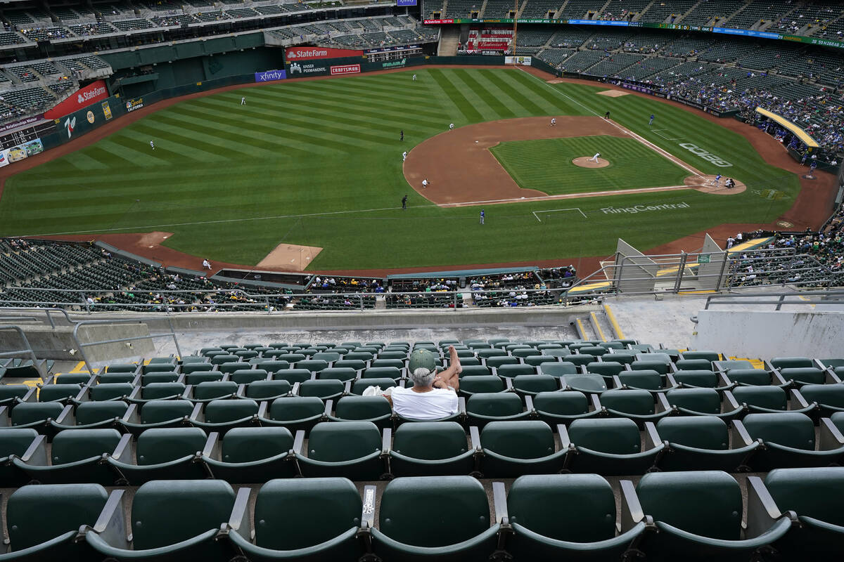 A fan sitting in the upper deck at RingCentral Coliseum watches a baseball game between the Oak ...