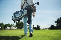 Golf man walking with shoulder bag on course in fairway (Getty Images)