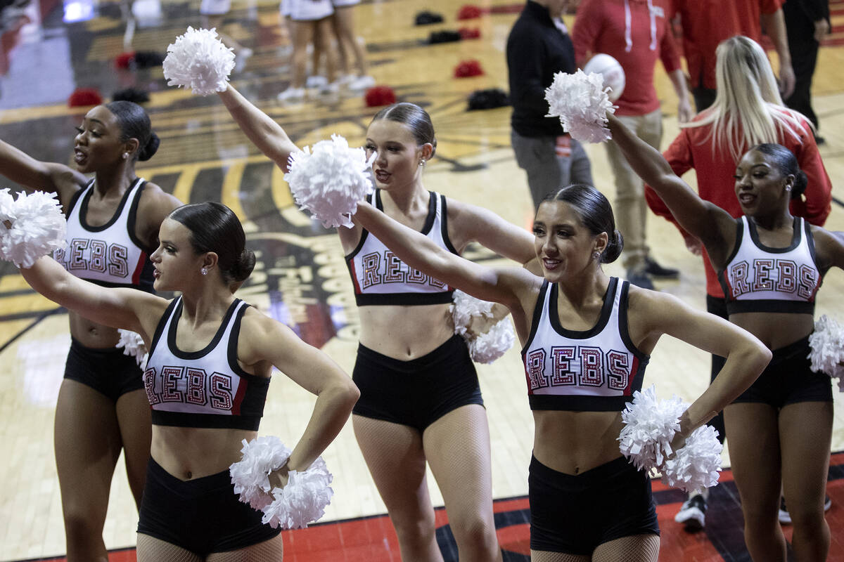 Rebel Girls & Company members cheer for their team from the sidelines during a UNLV basketball ...