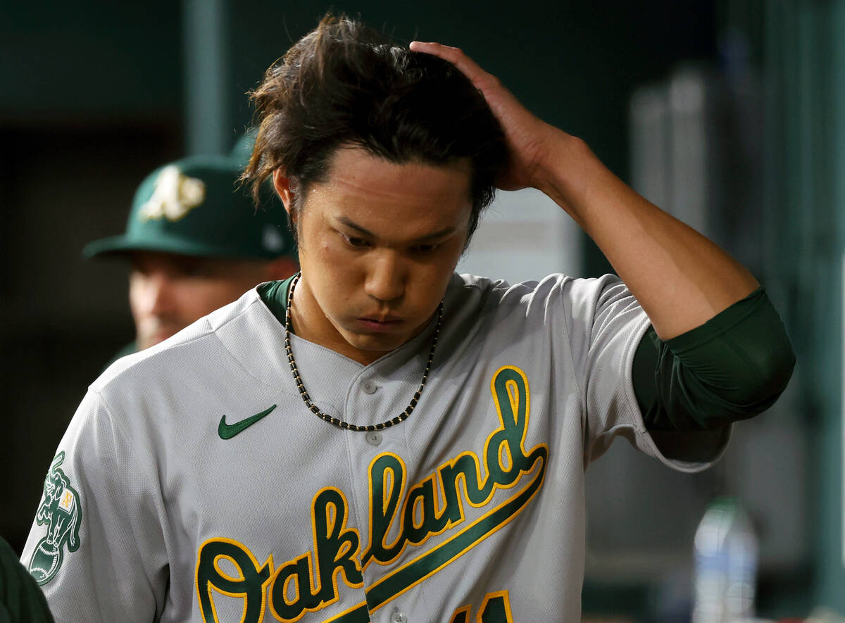 Oakland Athletics starting pitcher Shintaro Fujinami (11) reacts in the dugout after being reli ...
