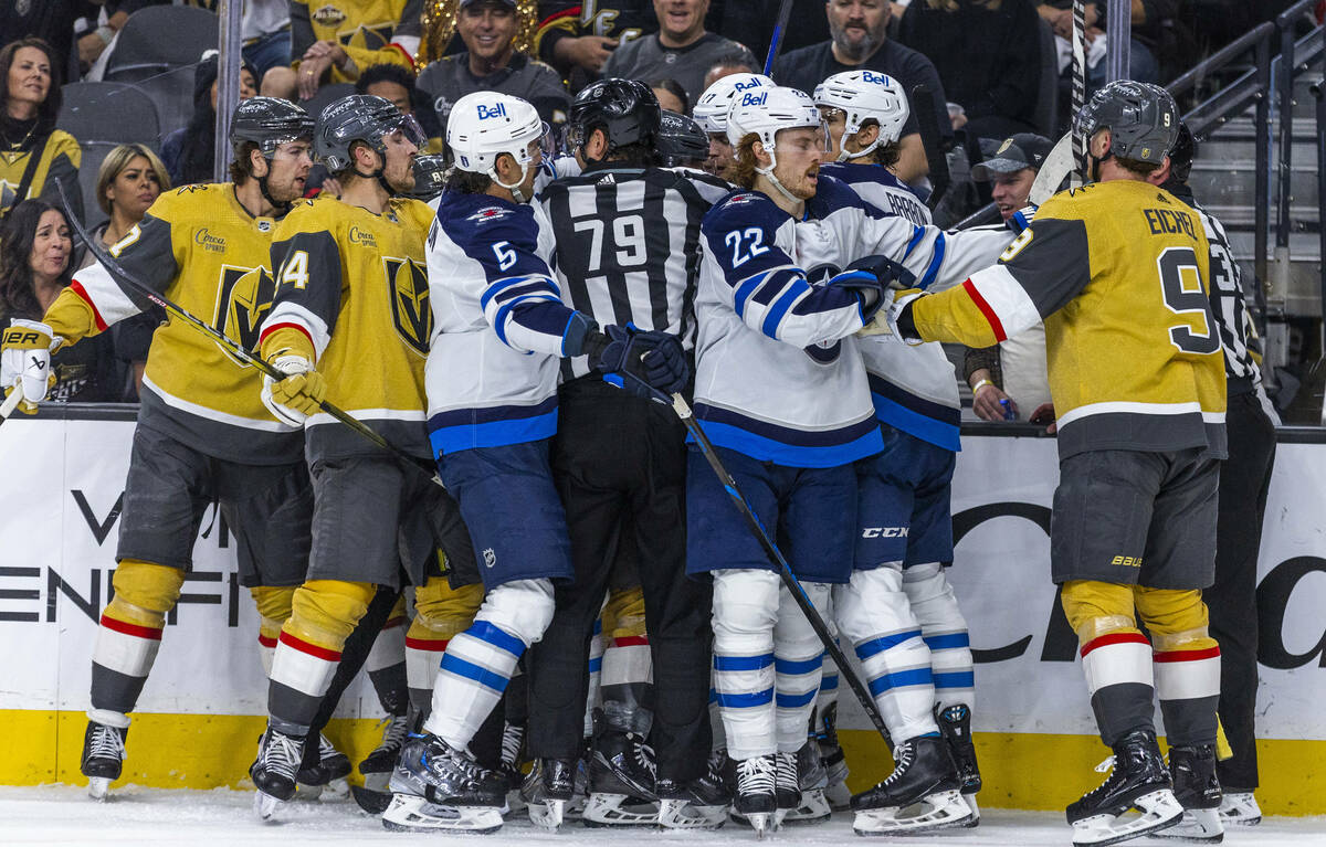 Golden Knights and Winnipeg Jets players scuffle during the first period in Game 5 of an NHL ho ...