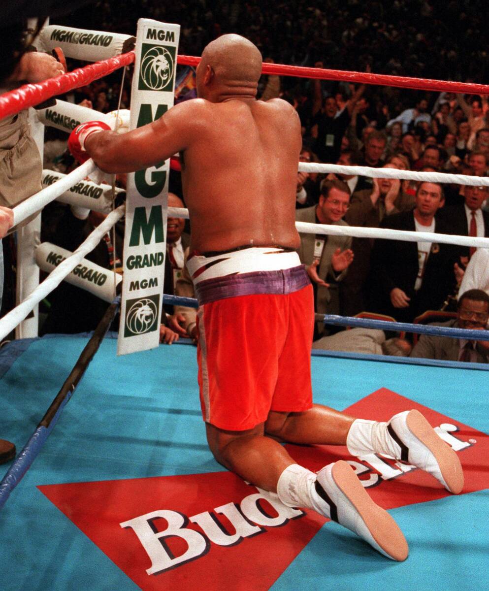 George Foreman kneels and prays after knocking out Michael Moorer in the 10 round on Saturday n ...