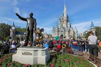 FILE - A statue of Walt Disney and Micky Mouse stands in front of the Cinderella Castle at the ...