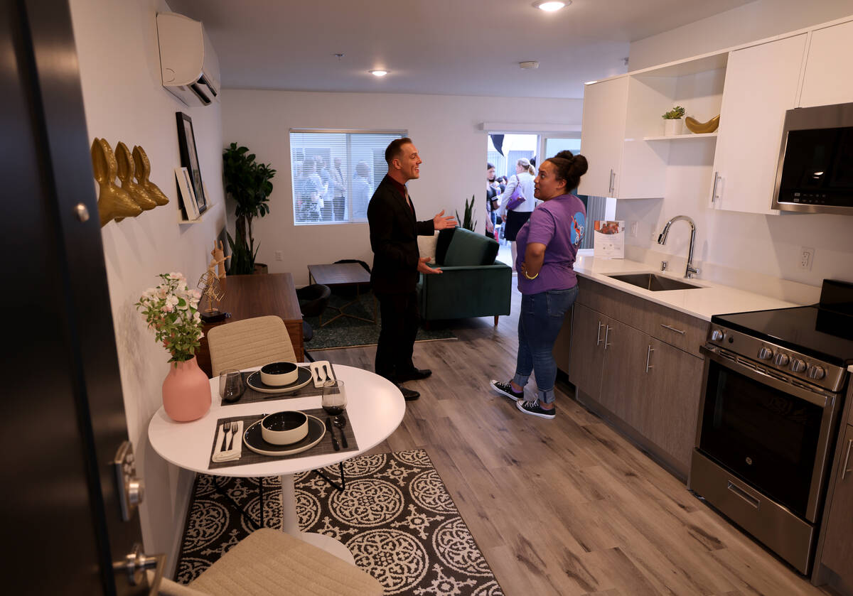 Property Manager Michael Reeves talks to Staci McDonald in a model unit at shareDowntown East F ...