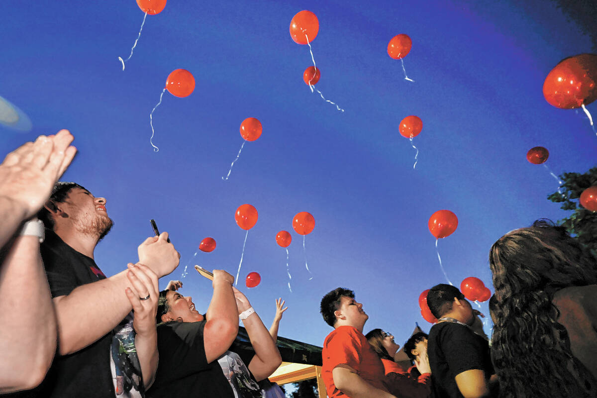 Jonathan Grace of Las Vegas, left, and his wife Taimane, second from left, release balloons wit ...