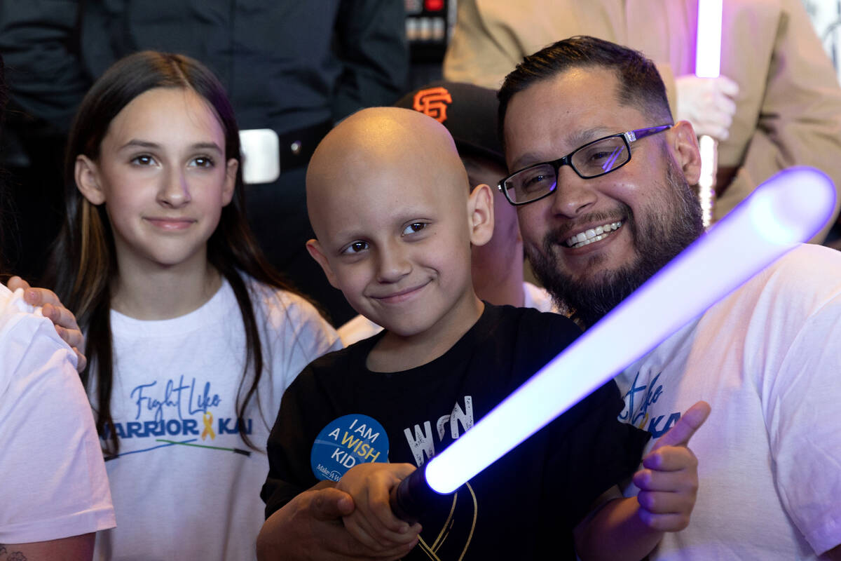 Kai Martinez, center, who was diagnosed with cancer in August, poses for photos after being gra ...