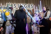 Kai Martinez, right, who was diagnosed with cancer in August, waves his new light saber around ...