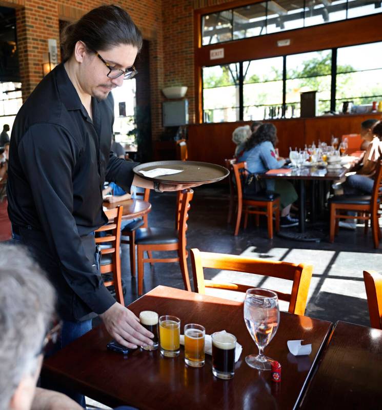 Waiter Edward Nutley serves a beer sampler at the Gordon Biersch brewery restaurant, Friday, Ap ...