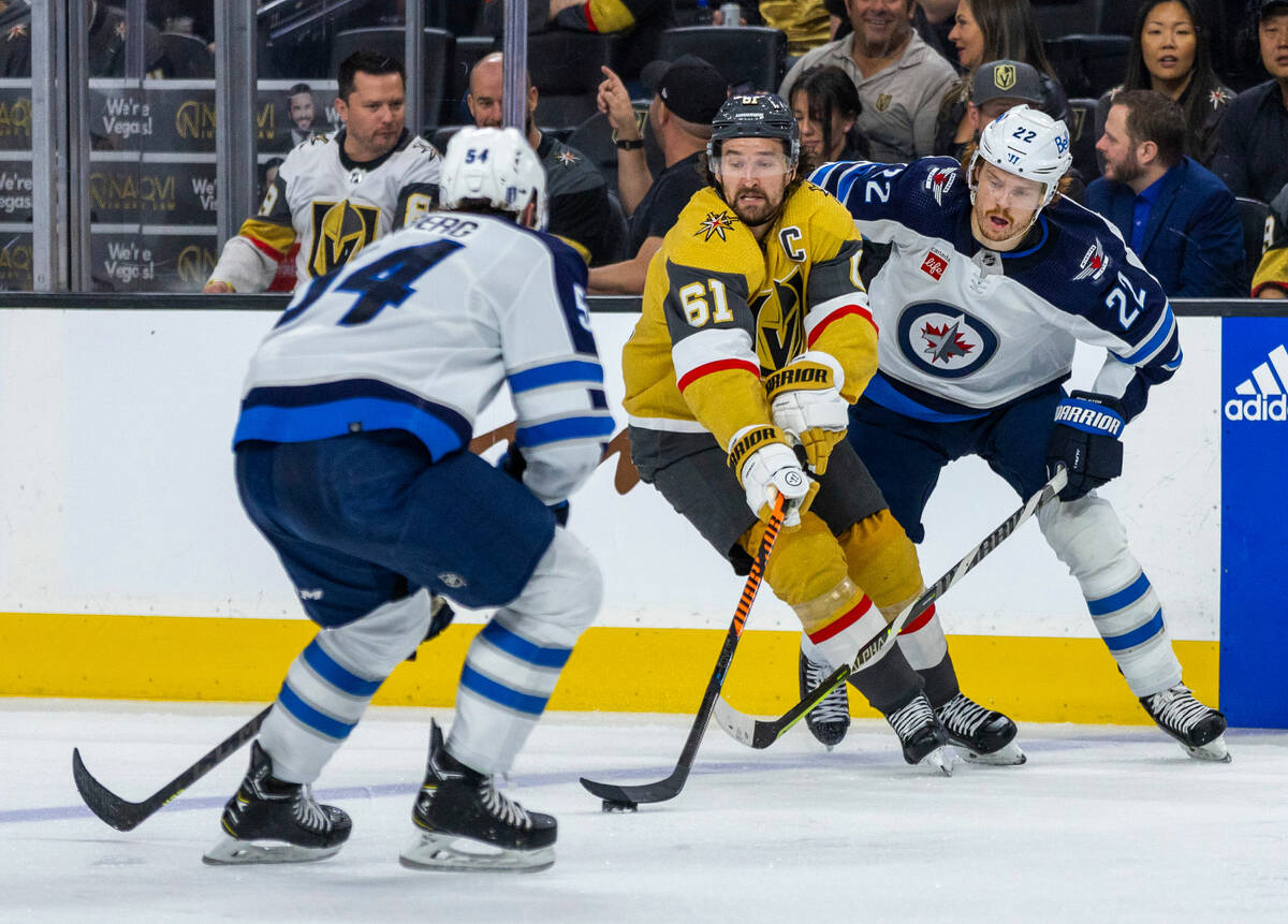 Golden Knights right wing Mark Stone (61) controls the puck between Winnipeg Jets defenseman Dy ...