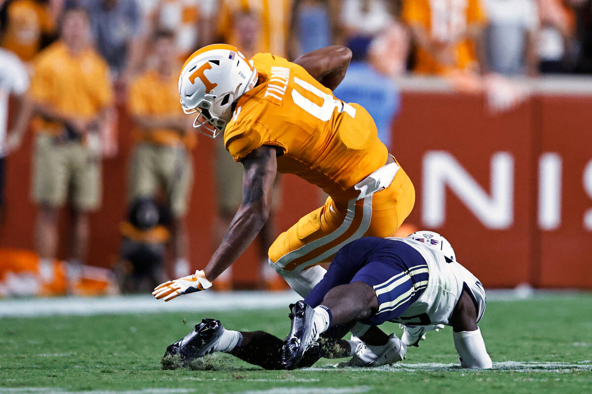 Tennessee wide receiver Cedric Tillman (4) is hit by Akron cornerback Tyson Durant (28) during ...