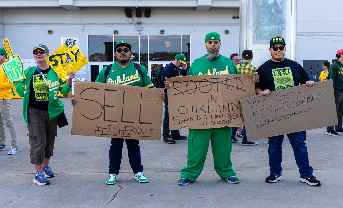 The Oakland A's fans hold signs as they protest outside of Oakland Coliseum before a baseball g ...