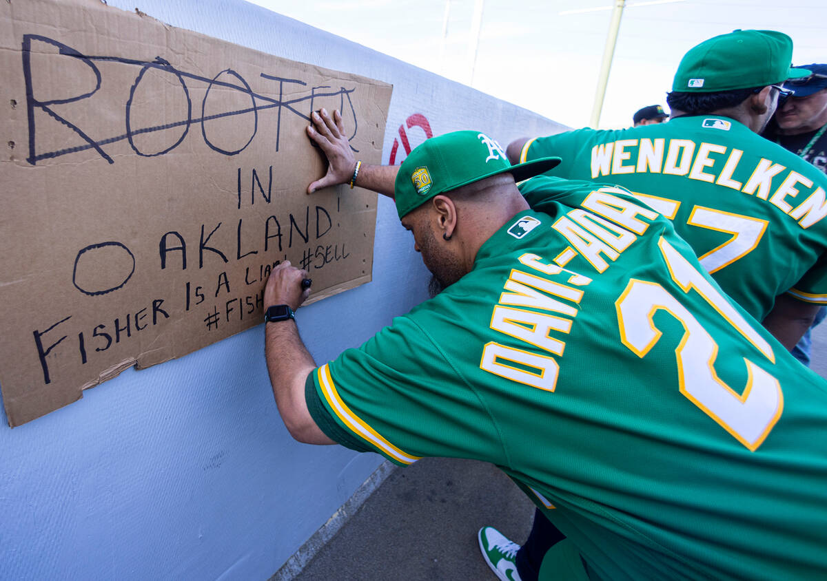 The Oakland A's fan Mike Davis-Adams prepares his sign as he protests outside of Oakland Colise ...