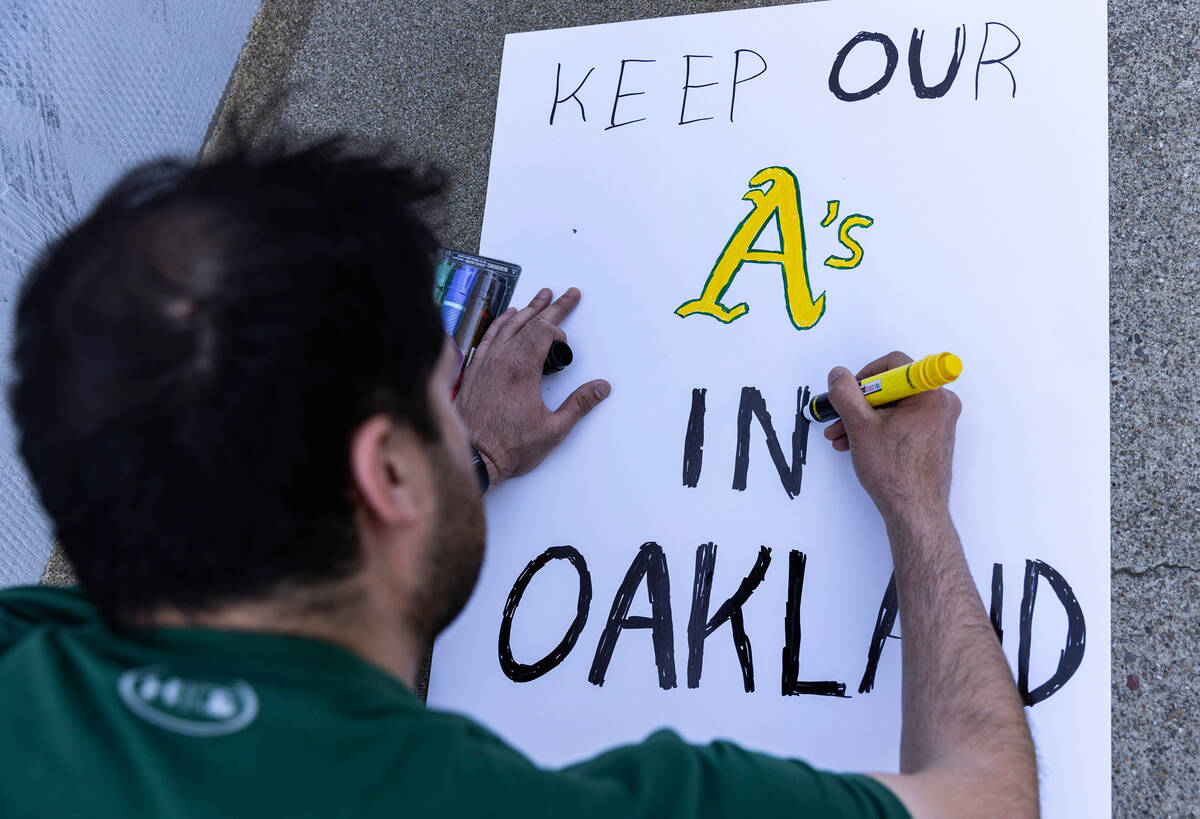 The Oakland A's fan Chris Prokop prepares his sign as he protests outside of the Oakland Colise ...