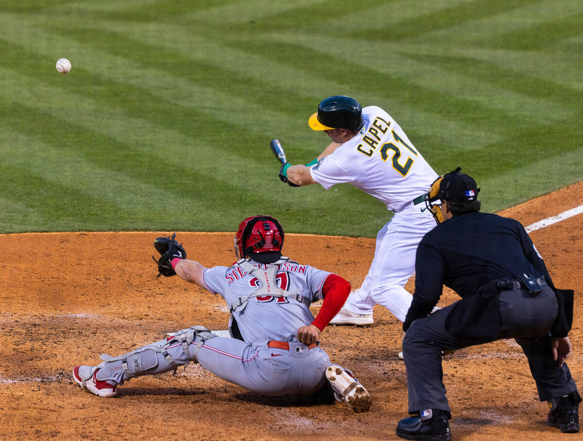 The Oakland A's outfielder Conner Capel (21) swings against the Cincinnati Reds during a baseba ...