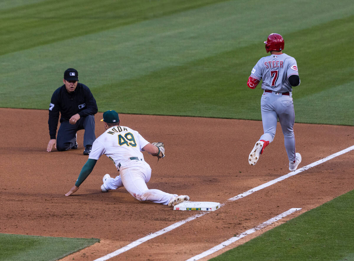The Cincinnati Reds infielder Spencer Steer (7) is forced out by The Oakland A's first baseman ...