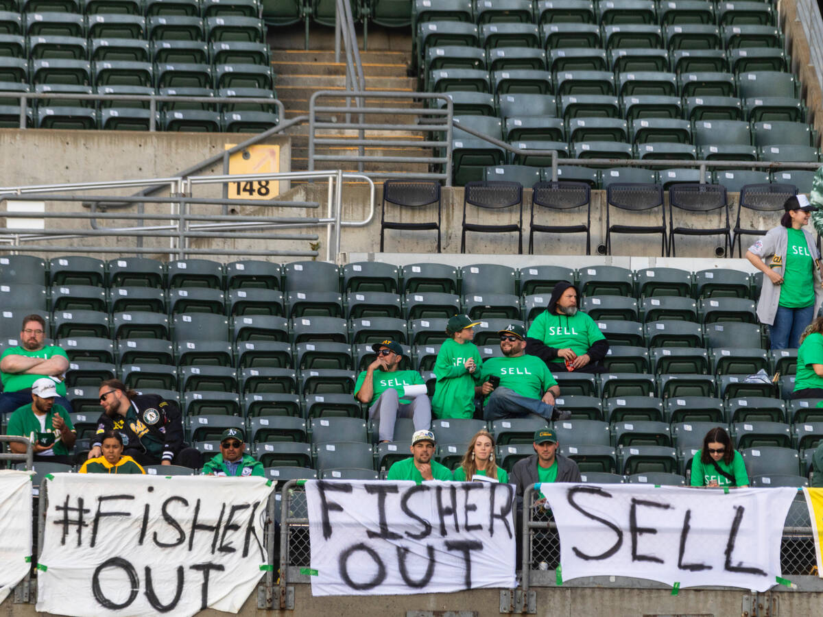 The Oakland A's fans display signs as they protest at the Oakland Coliseum during a baseball ga ...