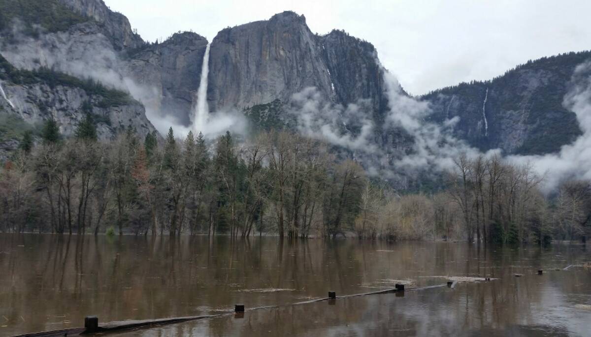 Floodwaters cover Cooks Meadow and the pedestrian trail through Cooks Meadow in Yosemite Valley ...
