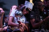 Las Vegas Aces forward A'ja Wilson laughs with guard Jackie Young while holding the 2022 WNBA C ...