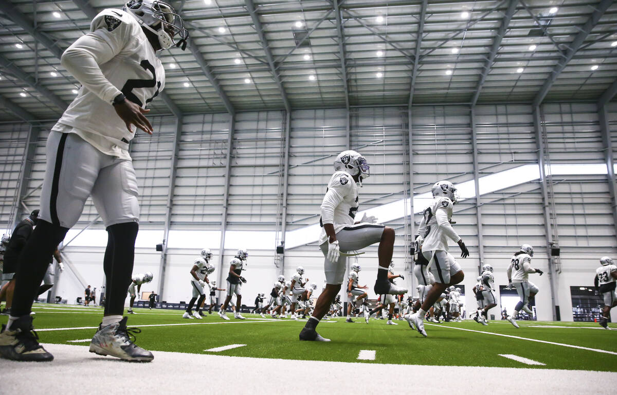 Las Vegas Raiders players warm up during an NFL training camp practice in Henderson on Aug. 25, ...