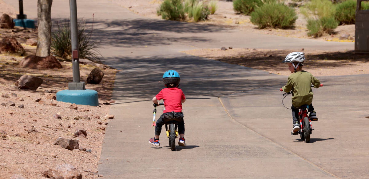 Asher, 3, and his brother Lucas, 4, ride their bikes in Acacia Park in Henderson Friday, May 5, ...