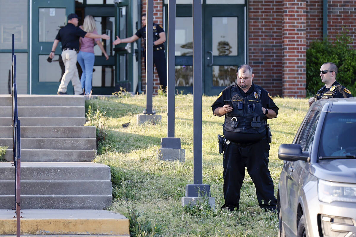 Law enforcement stand outside of Henryetta High School, Monday, May 1, 2023, as people arrive f ...