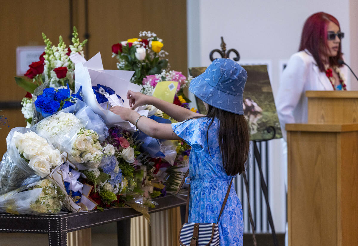 Nacy Diaz places a poem she wrote amongst flowers during a funeral service for Tabatha Tozzi at ...