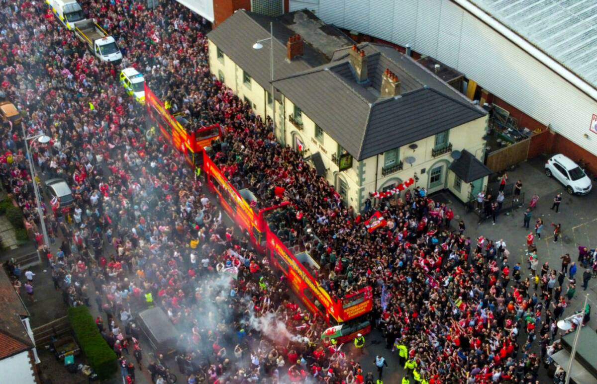 An aerial view of open-top busses carrying Wrexham players passes the Racecourse Ground, home o ...