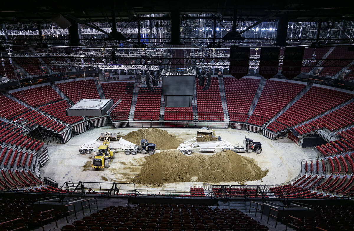 Workers take the dirt out of the arena after the conclusion of National Finals Rodeo at the Tho ...