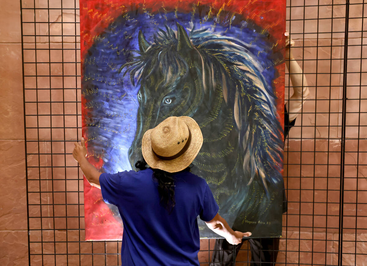 Visiting Mexican artist Olegario Hernández Mendoza hangs some of his art in the rotunda at the ...