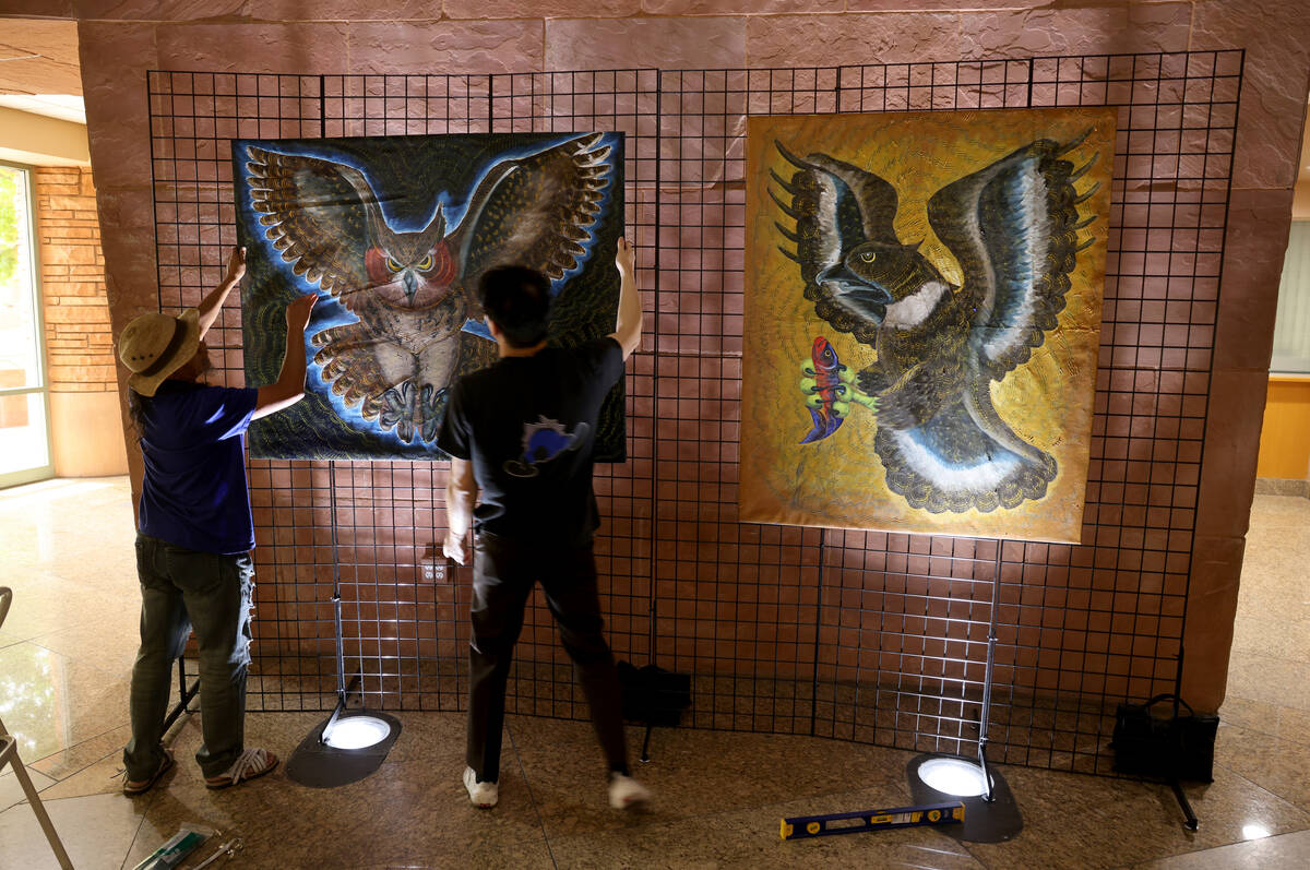 Visiting Mexican artist Olegario Hernández Mendoza, left, and Sonny Tsoi hang some of Hernande ...