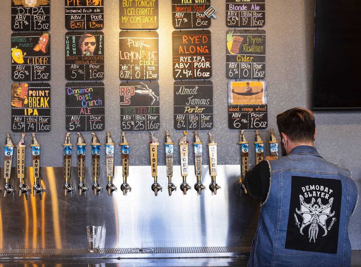 Kyler Bailey, a “beertender,” fills beer into pint glasses at Mojave Brewing, on ...