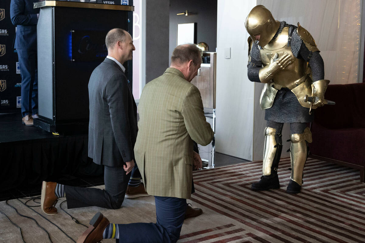 Lee the Golden Knight, right, knights Scripps Company CEO Adam Symson, left, and Scripps Sports ...