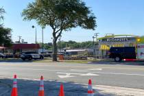 Police vehicles sit parked in front of a McDonald's restaurant as police investigate a shooting ...