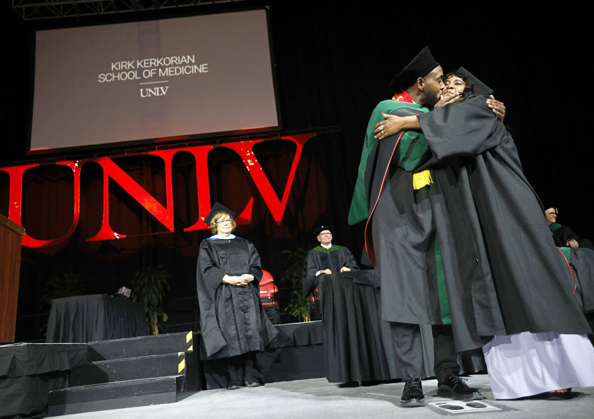 Sami Mesgun kisses his mother Azmara Zeratsion after he was hooded by Zeratsion during the comm ...