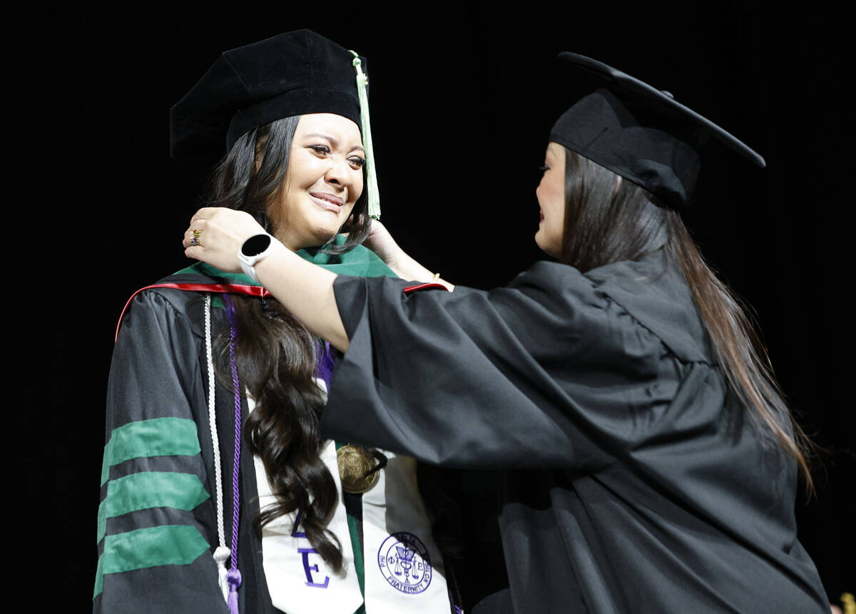 Ashley Crystal Davitt is hooded by her mother Corrina Davitt during the commencement and academ ...