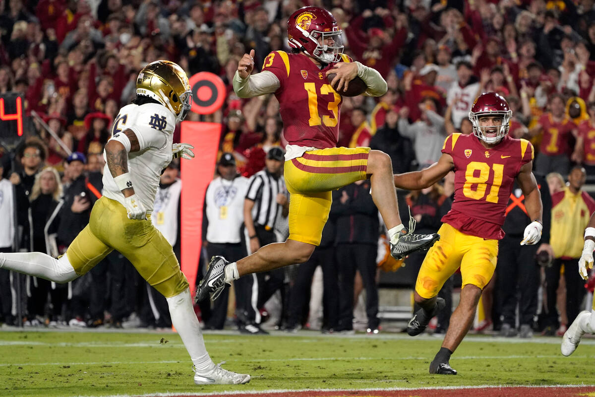 Southern California quarterback Caleb Williams jumps in for a touchdown as Notre Dame safety Xa ...