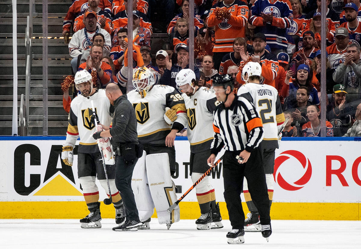 Teammates and an athletic trainer tend to Vegas Golden Knights goalie Laurent Brossoit (39) whi ...