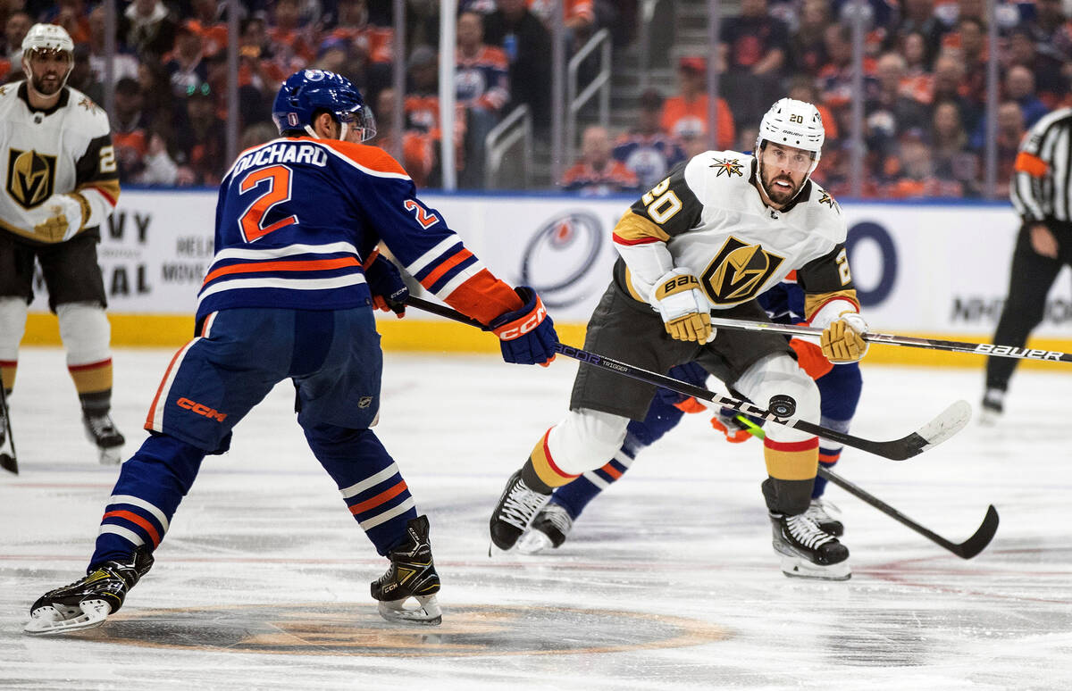 Vegas Golden Knights' Chandler Stephenson (20) and Edmonton Oilers' Evan Bouchard (2) battle fo ...