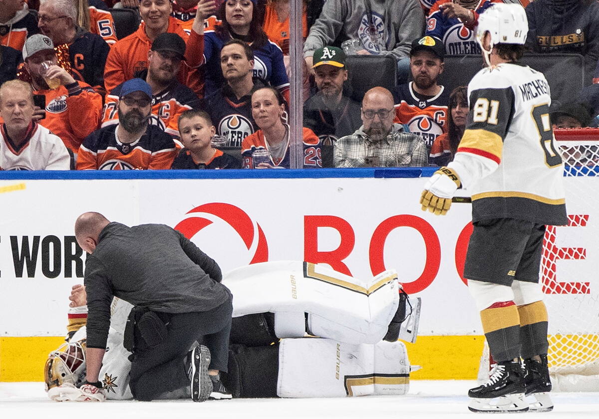 An athletic trainer tends to Vegas Golden Knights goalie Laurent Brossoit while playing the Edm ...